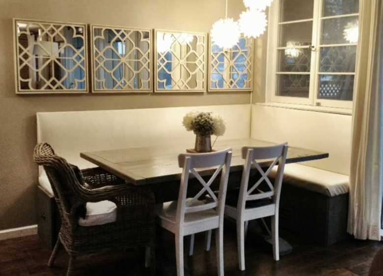dark hardwood dining rooom table with white seating and white home decor and lighting